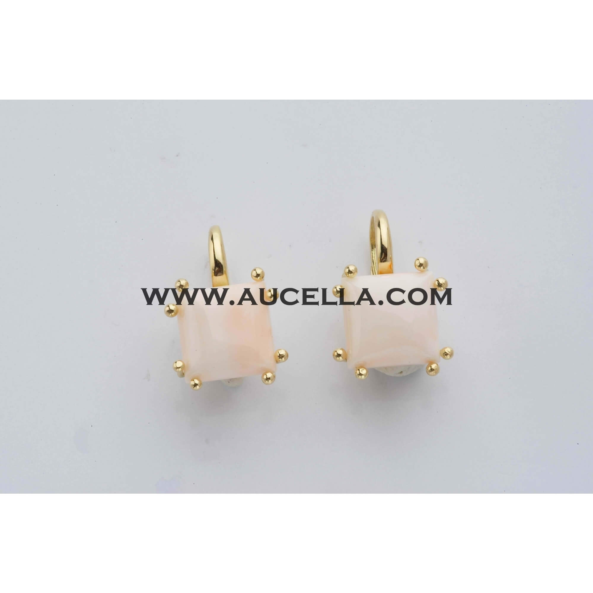 Earrings set in gold with pink coral cabochon